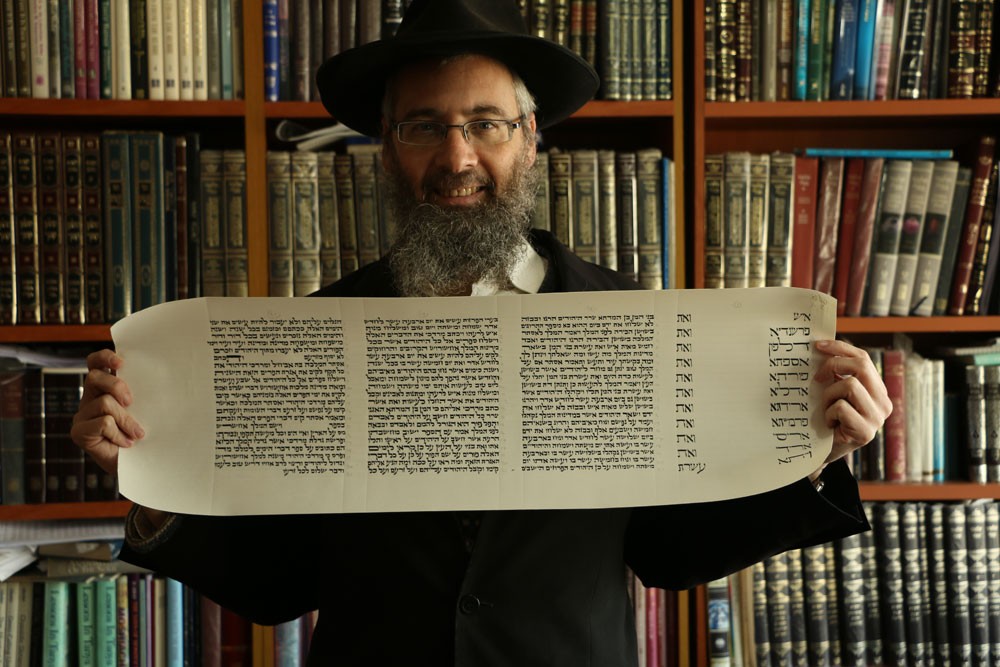 Eliyahu Shear showing the last sheet of the Megillah he wrote
